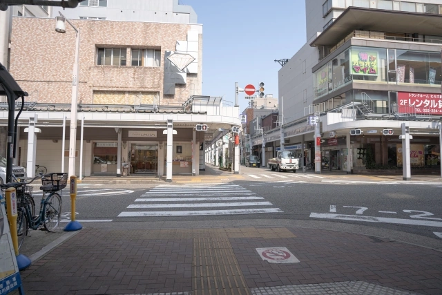 A street intersection and covered shopfronts in Niigata City's Furumachi district.