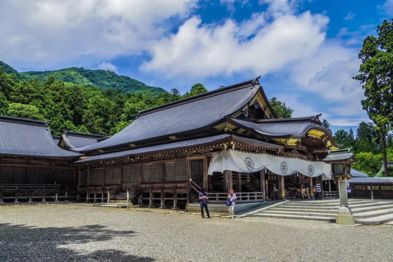 The worship hall at Yahiko Shrine with wooded hills behind it.