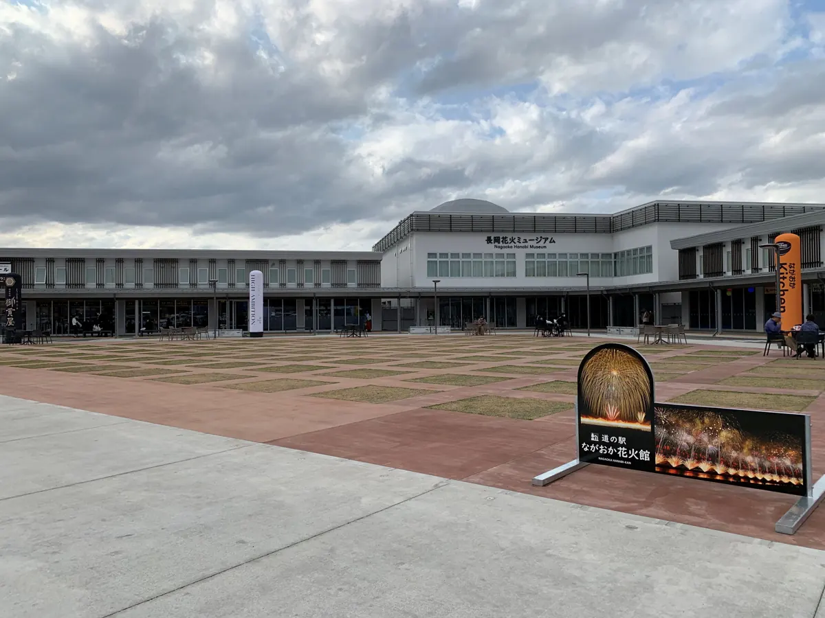 The Nagaoka Fireworks Museum faces a broad courtyard with a fireworks-themed sign.