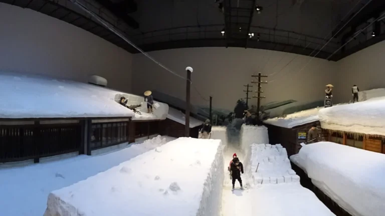 A reconstructed snow-covered Takada street with houses and figures inside the Niigata Prefectural Museum of History.