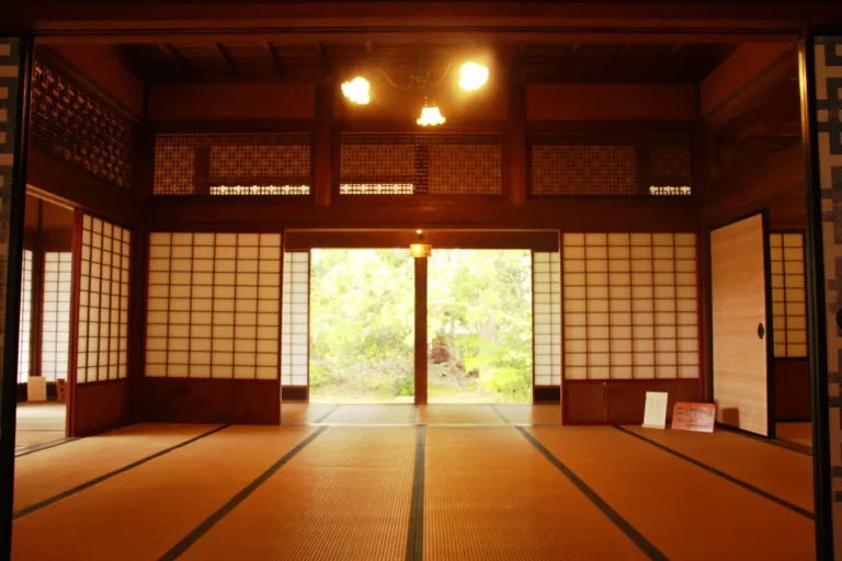 Tatami rooms and dark timber frame a garden view at the Former Sasagawa Residence.