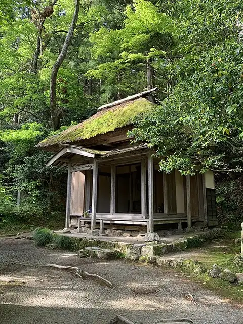 Gogoan hermitage with a moss-covered roof among green trees on Mount Kugami