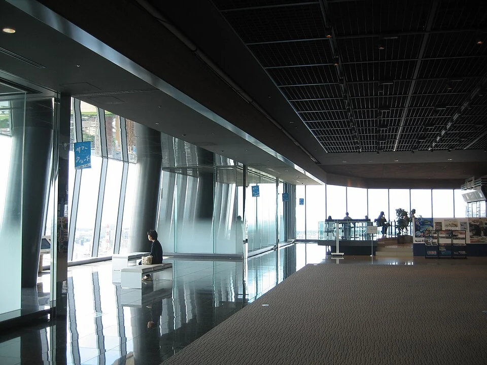 Visitors beside the tall windows of Media Ship’s twentieth-floor observation lounge