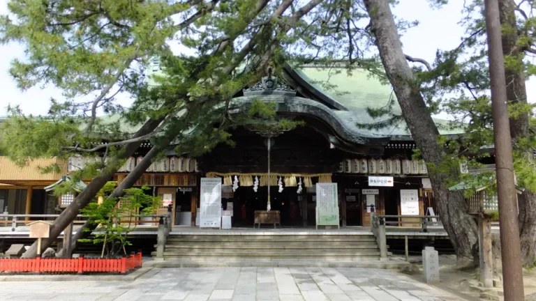 The worship hall of Niigata Hakusan Shrine framed by trees, photographed on 6 May 2018.