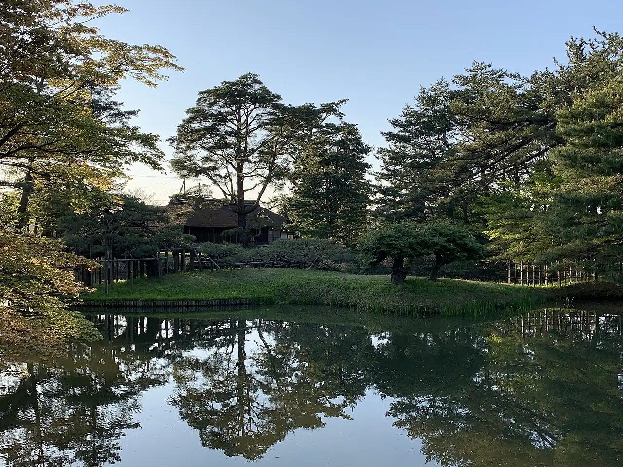 Pond, pine trees and teahouse at Ijimino Ochaya Garden